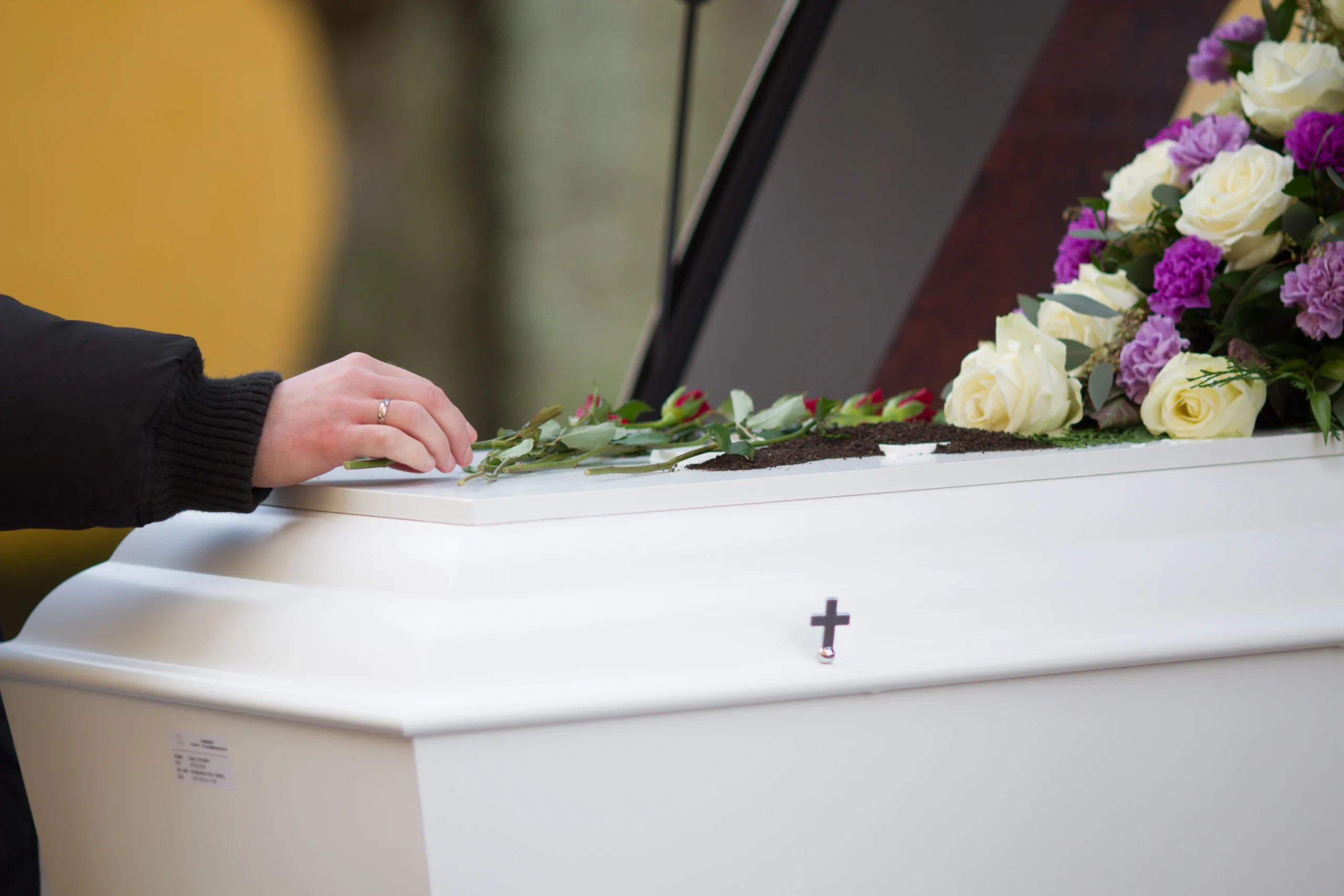 closeup-shot-person-hand-casket-with-blurred-background-scaled